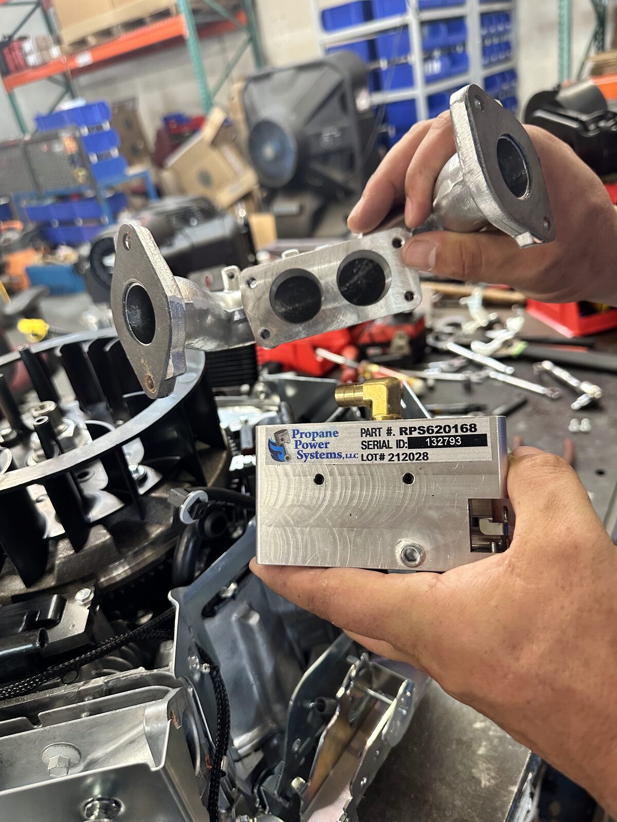 2 J's Equipment Repair technician installing a Propane Power Systems part on a small engine